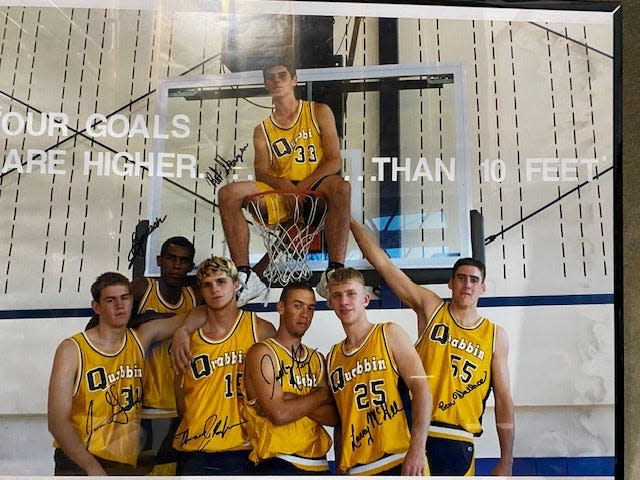 Quabbin seniors from the 1998-99 season pose in front of the basket for a group shot. The team, which won the Central Mass. title and the Clark Tournament, is being celebrated at the Quabbin boys basketball game on February 2, 2024.