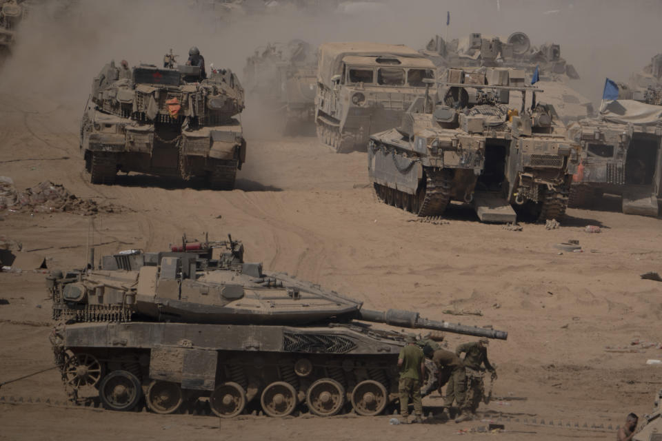 Israeli soldiers work on a tank in a staging area near the Israeli-Gaza border in southern Israel, Monday, June 3, 2024. (AP Photo/Leo Correa)