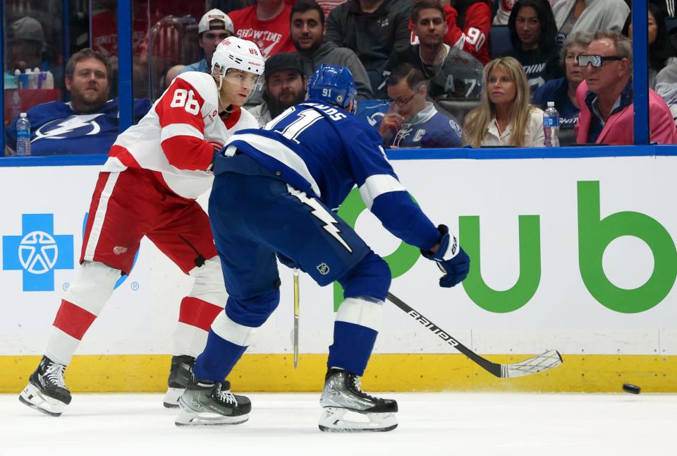 Detroit Red Wings right wing Patrick Kane passes the puck as Tampa Bay Lightning center Luke Glendening defends during the second period at Amalie Arena in Tampa, Florida on April 1, 2024.