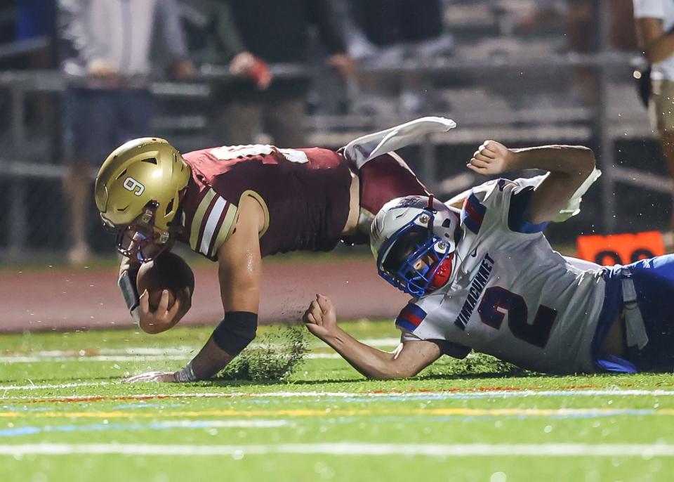 Portsmouth's Brooks Connors dives ahead for an extra yard as Winnacunnet's DJ Scaicca makes the tackle in the first half of Friday's Division I football game. Portsmouth improved to 2-0 on the season with a 42-0 win over Warriors.