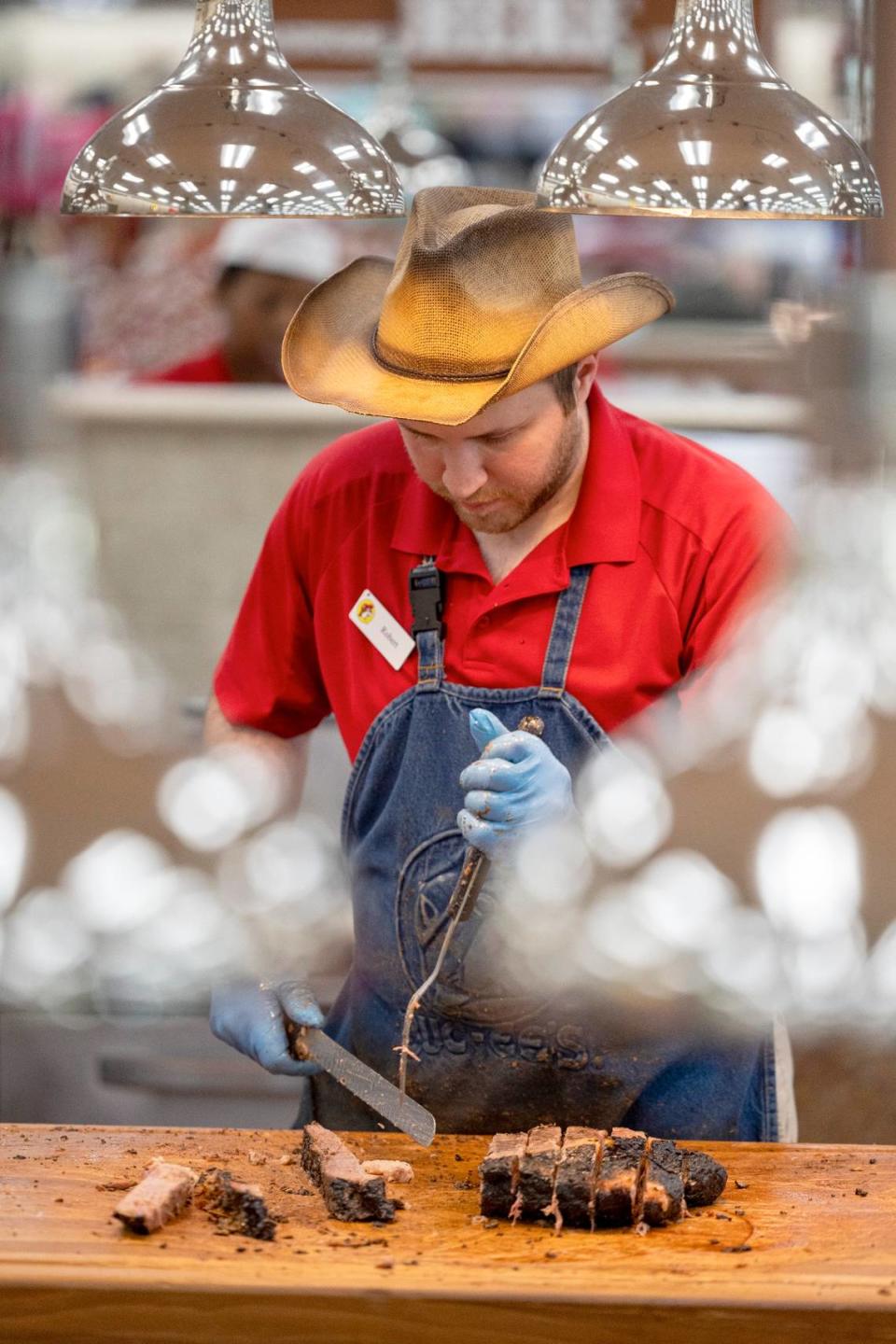 A Buc-ee’s employee prepares sliced brisket on a cutting board at Buc-ee’s in Florence, SC.