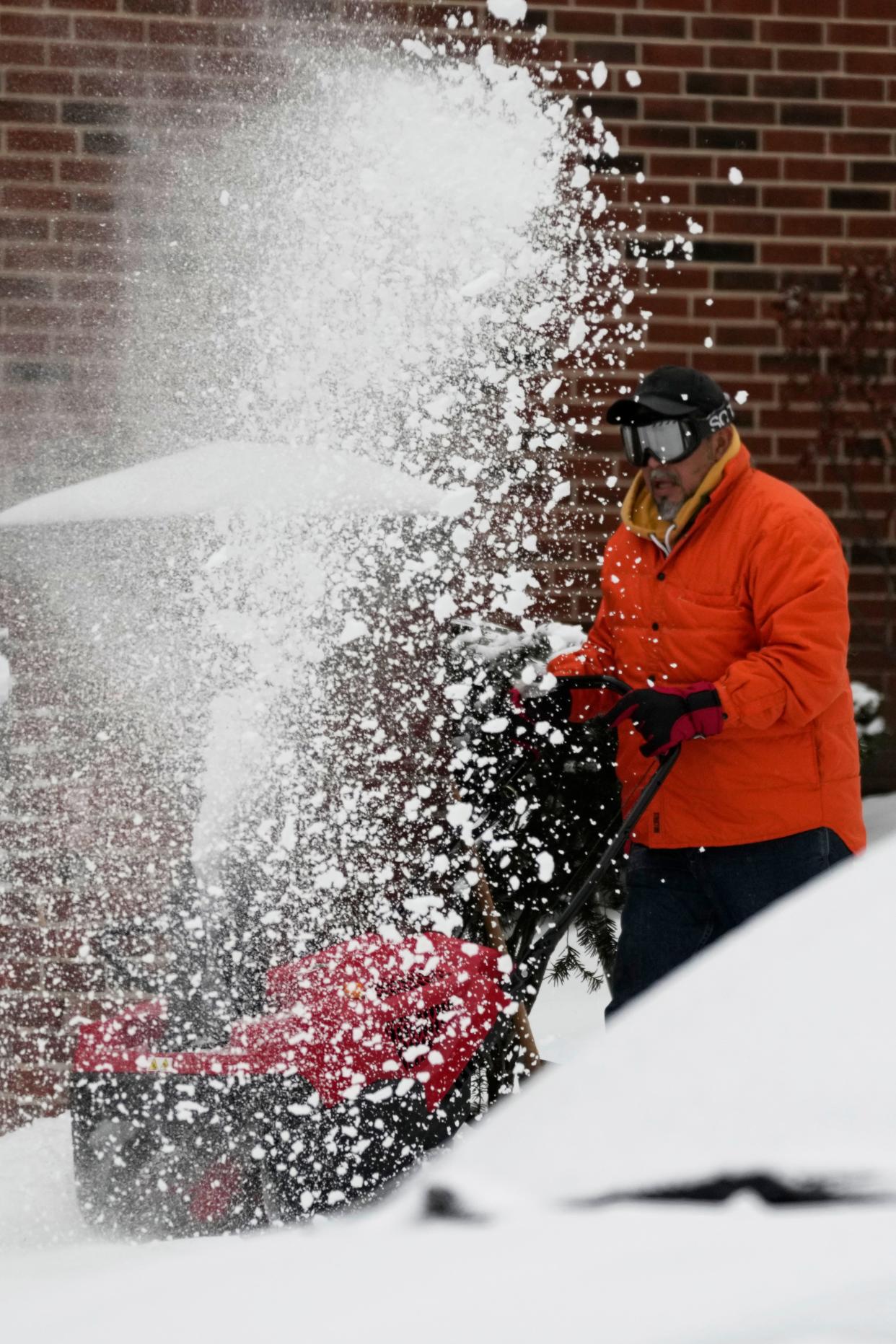 A man clears snow from a sidewalk on Jan. 29, 2023, in Evanston, Ill.
