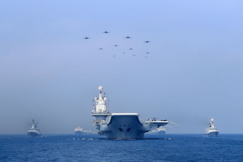 Warships and fighter jets of Chinese People's Liberation Army (PLA) Navy take part in a military display in the South China Sea