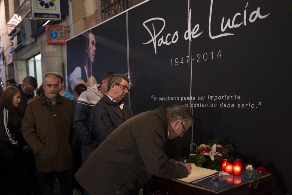 People sign a message in a book of condolence for late Spanish flamenco guitarist Paco de Lucia in town of Algeciras, southern Spain, Friday, Feb. 28, 2014. Paco de Lucia, one of the world's greatest guitarists who dazzled audiences with his lightning-speed flamenco rhythms and finger work, died in Mexico on Wednesday Feb. 26. aged 66. He is due to be buried in Algeciras later Saturday. (AP Photo/Laura Leon)