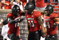 Louisville running back Trevion Cooley (23) celebrates with wide receiver Justin Marshall (18) and tight end Dez Melton (84) following his touchdown during the second half of an NCAA college football game against Central Florida in Louisville, Ky., Friday, Sept. 17, 2021. (AP Photo/Timothy D. Easley)