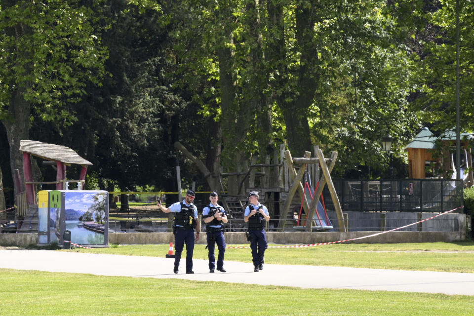 Police officers walk near a playground in Annecy, French Alps, Thursday, June 8, 2023. An attacker with a knife stabbed several young children and at least one adult, leaving some with life-threatening injuries, in a town in the Alps on Thursday before he was arrested, authorities said. (Jean-Christophe Bott/Keystone via AP)