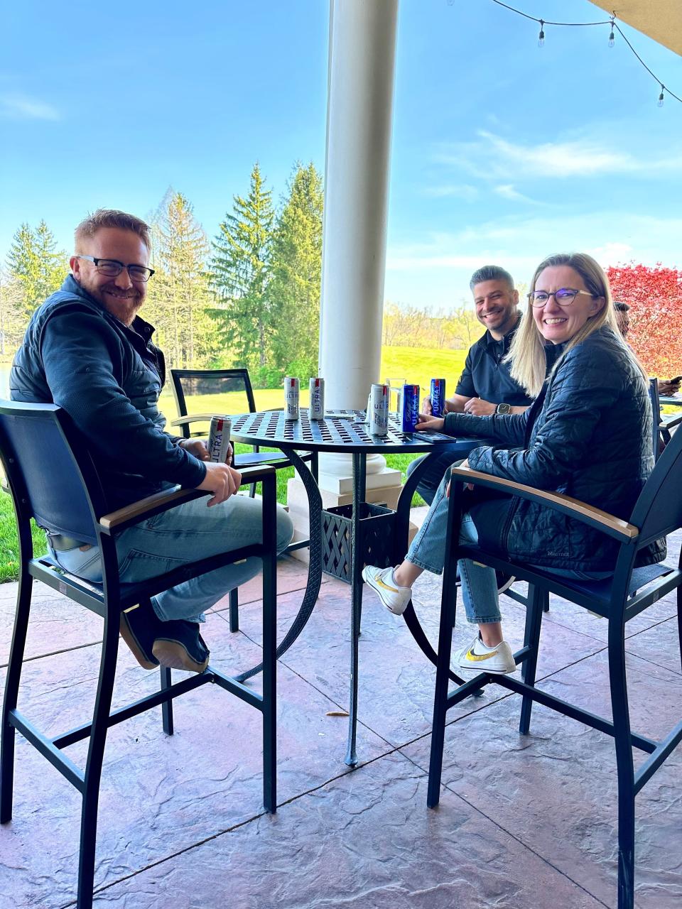 A trio of friends enjoy the sunshine on the patio at The Quarry public golf course in Canton.