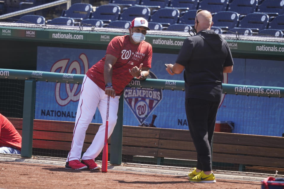 CORRECTS FIRST NAME TO MIKE-Washington Nationals manager Dave Martinez, left, and general manager Mike Rizzo talk during a baseball workout at Nationals Park, Monday, April 5, 2021, in Washington. The Nationals are scheduled to play the Braves on Tuesday. (AP Photo/Alex Brandon)