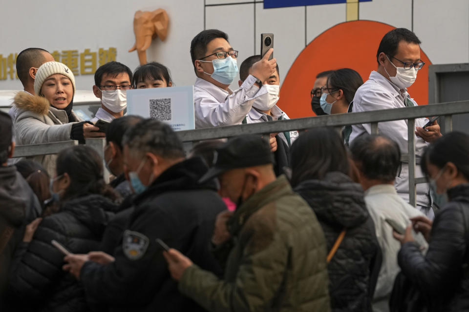 Service sector workers wearing face masks to help curb the spread of the coronavirus line up during a mass COVID-19 testing in Beijing, Friday, Oct. 29, 2021, following a spike of the coronavirus in the capital and other provincials. (AP Photo/Andy Wong)