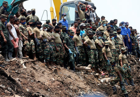 Members of the military wait until another rescue team recovers a dead victim during a rescue mission after a garbage dump collapsed and buried dozens of houses in Colombo, Sri Lanka April 16, 2017. REUTERS/Dinuka Liyanawatte