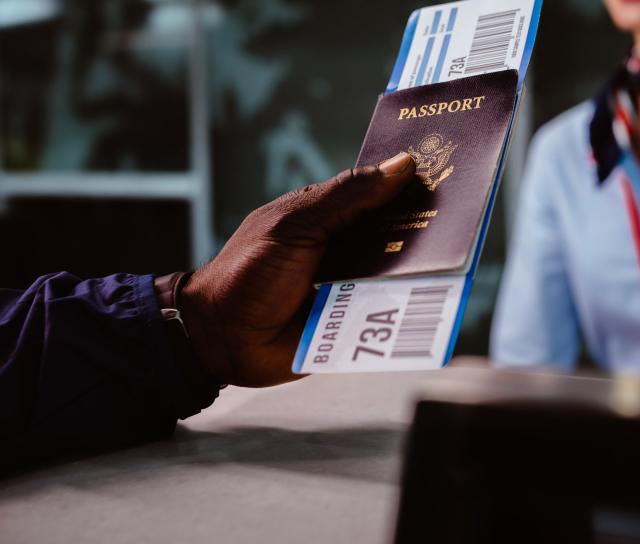 A person holding a passport at an airport gate.