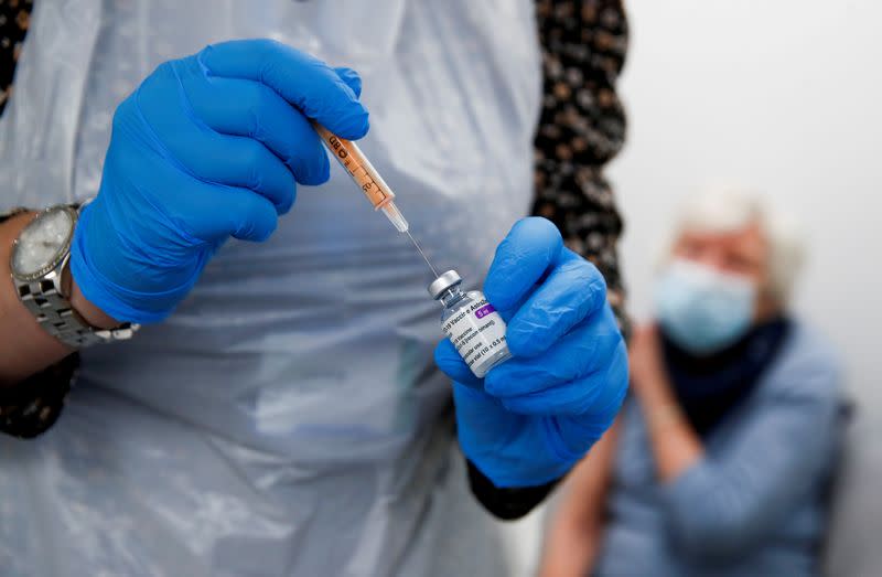 FILE PHOTO: A health worker fills a syringe with a dose of the Oxford/AstraZeneca COVID-19 vaccine