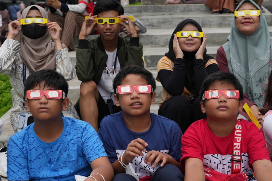 FILE - Youths wear protective glasses to watch a hybrid solar eclipse in Jakarta, Indonesia, Thursday, April 20, 2023. On Saturday, Oct. 14, 2023, an annular solar eclipse _ better known as a ring of fire _ will briefly dim the skies over parts of the western U.S. and Central and South America. Proper protection is needed throughout the eclipse, from the initial partial phase to the ring of fire to the final partial phase. (AP Photo/Tatan Syuflana, File)