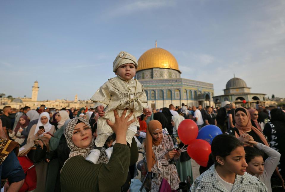 Muslims celebrate in front of the Dome of the Rock mosque after the morning Eid al-Fitr prayer, which marks the end of the holy fasting month of Ramadan, at the Al-Aqsa mosques compound in Old Jerusalem early on May 2, 2022.