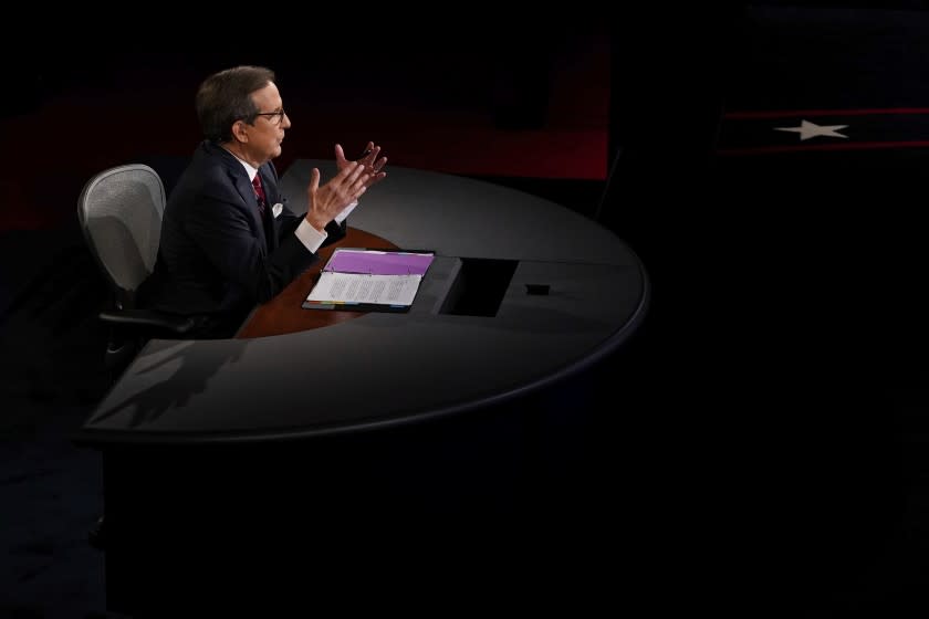 Moderator Chris Wallace of Fox News gestures toward President Donald Trump and Democratic presidential candidate former Vice President Joe Biden during the first presidential debate Tuesday, Sept. 29, 2020, at Case Western University and Cleveland Clinic, in Cleveland, Ohio. (AP Photo/Morry Gash, Pool)