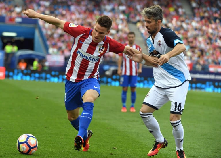 Atletico Madrid's forward Kevin Gameiro (L) clashes with Deportivo La Coruna's defender Luisinho on September 25, 2016