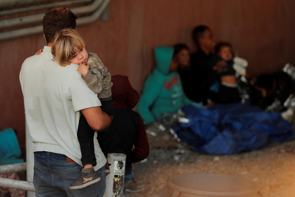 A man holds a child inside an enclosure, where they are being held by U.S. Customs and Border Protection (CBP), after crossing the border between Mexico and the United States illegally and turning themselves in to request asylum, in El Paso, Texas, U.S., March 29, 2019. (Photo: Lucas Jackson/Reuters)