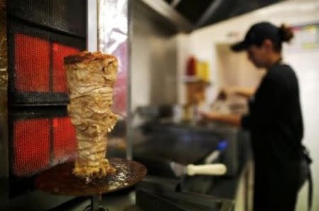 An employee prepares a kebab at a restaurant in Clisson, Western France October 27, 2014. In a country whose national identity is so closely connected to its cuisine, France's hard right has seized on a growing appetite for kebabs as proof of cultural "islamisation". REUTERS/Stephane Mahe