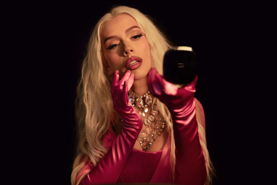 christina aguilera looking at her reflection in a dolce and gabbana compact mirror
