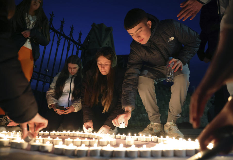 Youth from St. Peter's Immaculata Youth Centre and the Townsend Street Social Outreach Centre light candles at Belfast City cemetery for Holocaust Remembrance Day, in west Belfast, Northern Ireland, Friday, Jan. 27, 2023. Twenty-five years ago, the Good Friday Agreement halted much of the violence of Northern Ireland’s Troubles. Today, grassroots faith leaders are trying to build on that opportunity. They're working toward reconciliation in a land where religion was often part of the problem. (AP Photo/Peter Morrison)