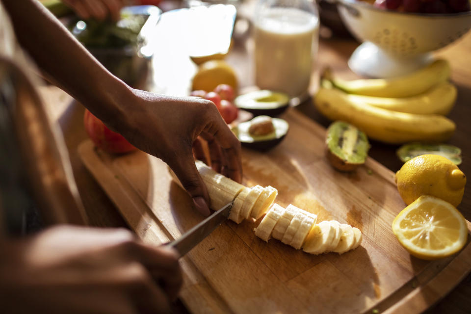 hands cutting up a banana