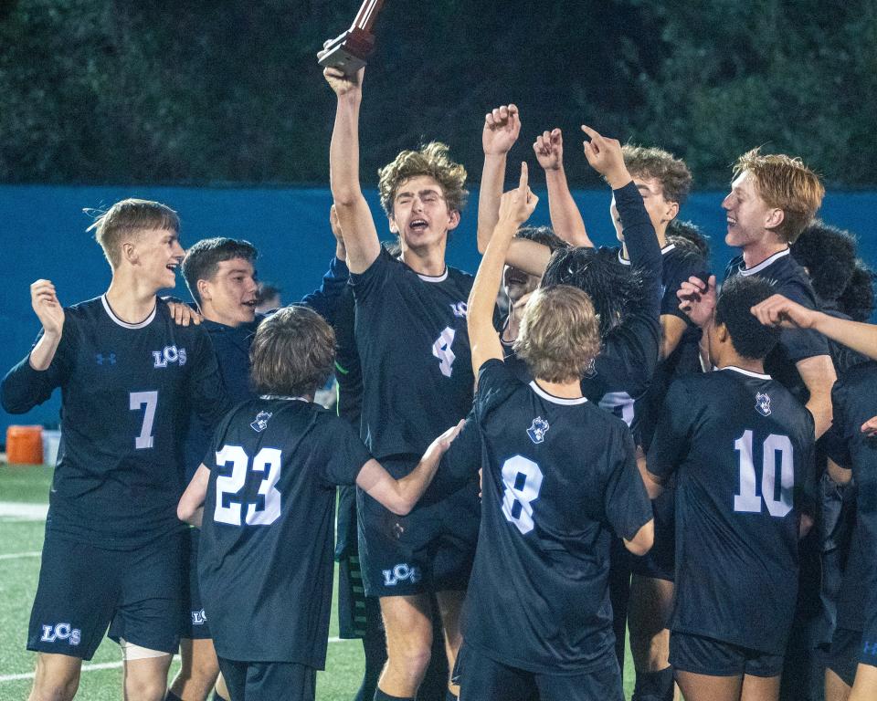 Lakeland Christian's Henry Strawbridge holds up the trophy after the Vikings defeated Seffner Christian, 4-0, on Thursday to win the Class 2A, Districtd 7 championship match at Viking Stadium.