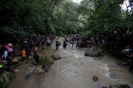 Honduran migrants cross the Lempa river, in the border line between Honduras and Guatemala near of Caliente to cross into Guatemala to join a caravan trying to reach the U.S, in Honduras October 17, 2018. REUTERS/Jorge Cabrera