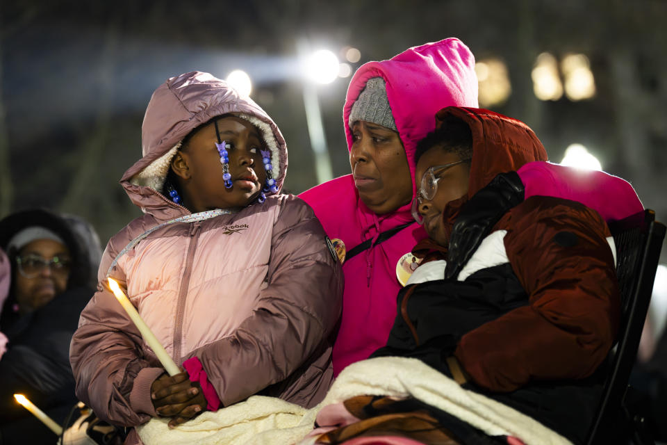 Nicole Williams checks on her grandchildren, Kennedy, 7, and Micah, 10, as they listen to their mother's name, Shawnika Denison, 31, read aloud from the homicide list during a vigil for the homicide victims of 2023 on Wednesday, Jan. 3, 2023 in Baltimore. Mayor Brandon Scott hosted the vigil. (Kaitlin Newman /The Baltimore Banner via AP)