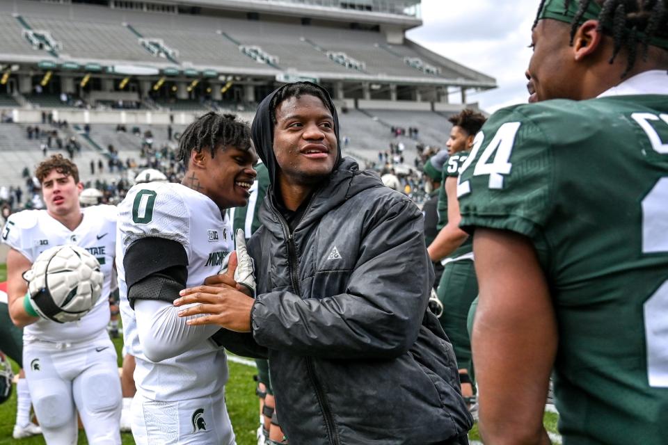 Former Michigan State running back Kenneth Walker III, center, interacts with Charles Brantley, left, and Elijah Collins at the end of the spring game on Saturday, April 16, 2022, at Spartan Stadium in East Lansing.