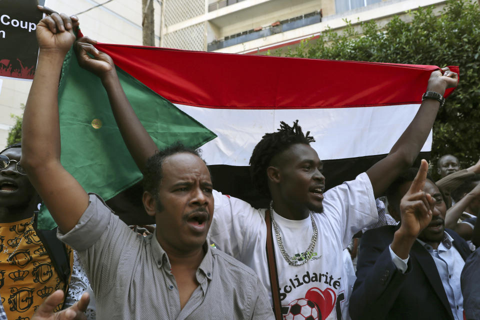 Sudanese nationals living in Lebanon chant slogans as they hold their national flag during a protest to condemn a military coup earlier this week, in front of the Sudanese Embassy in Beirut, Lebanon, Saturday, Oct. 30, 2021. The United Nations and the United States urged Sudan's top generals to allow pro-democracy protests Saturday and avoid confrontations in the wake of a military coup earlier this week. (AP Photo/Bilal Hussein)