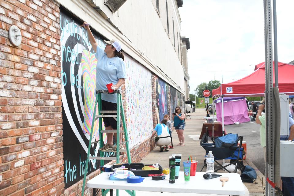 Lili Hair of Alexandria paints "The Heart of Louisiana" Friday at Alex RiverFete held Friday and Saturday. "We're right where we need to be," she said of Alexandria.