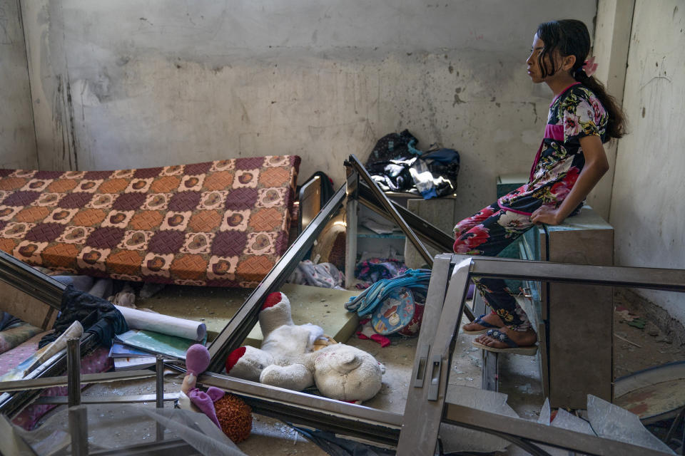 Amal Nassir, 11, sits for a portrait in her bedroom that was damaged when an airstrike destroyed the neighboring building prior to a cease-fire that halted an 11-day war between Gaza's Hamas rulers and Israel, Wednesday, May 26, 2021, in Beit Hanoun, Gaza Strip. (AP Photo/John Minchillo)