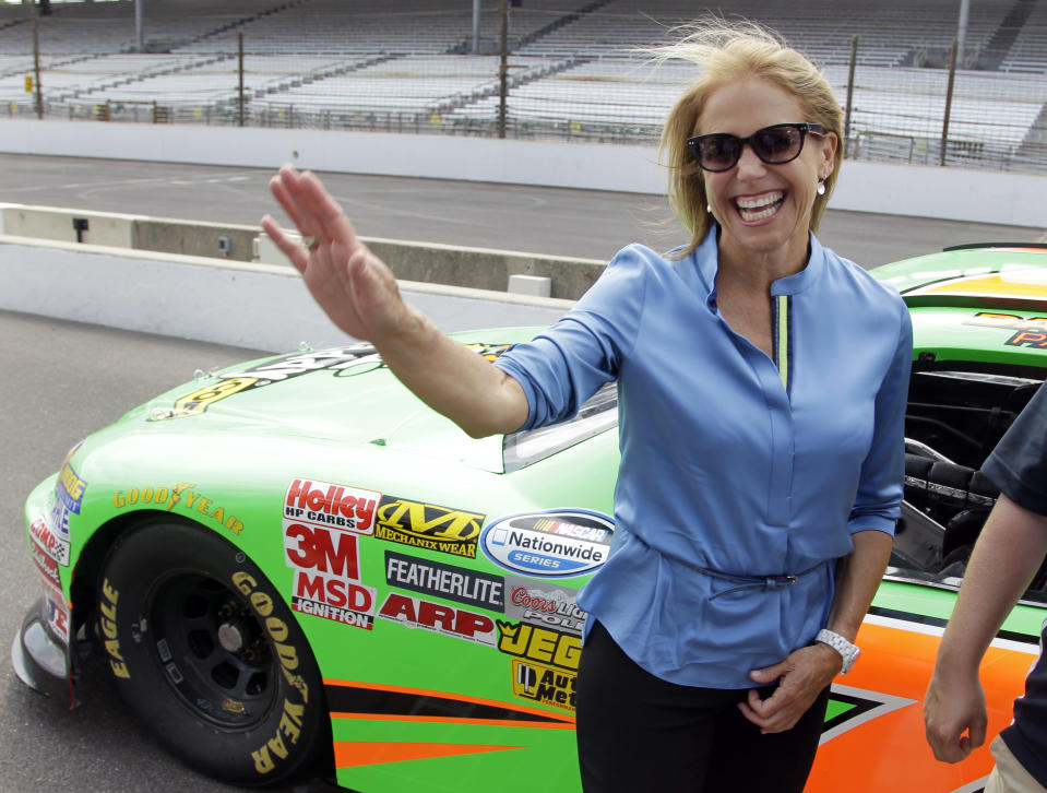 Journalist and television personality Katie Couric waves as she walks away from a car that she rode laps with race car driver Danica Patrick at the Indianapolis Motor Speedway in Indianapolis, Tuesday, July 10, 2012. (AP Photo/Michael Conroy)