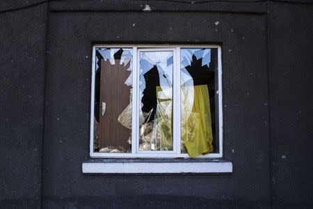 The broken window of a house damaged by fighting is seen in the town of Vuhlehirsk February 25, 2015. REUTERS/Baz Ratner