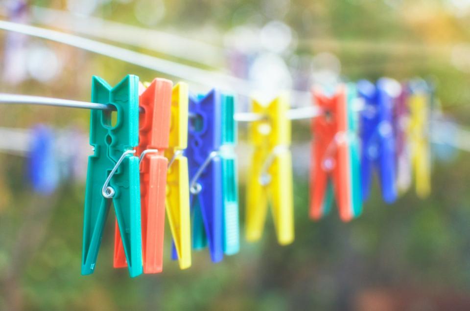 Colorful clothespins hanging in a row on a clothesline outside