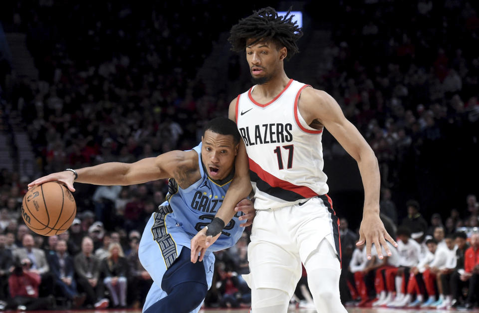 Memphis Grizzlies guard Desmond Bane, left, drives to the basket against Portland Trail Blazers guard Shaedon Sharpe, right, during the second half of an NBA basketball game in Portland, Ore., Sunday, Nov. 5, 2023. (AP Photo/Steve Dykes)