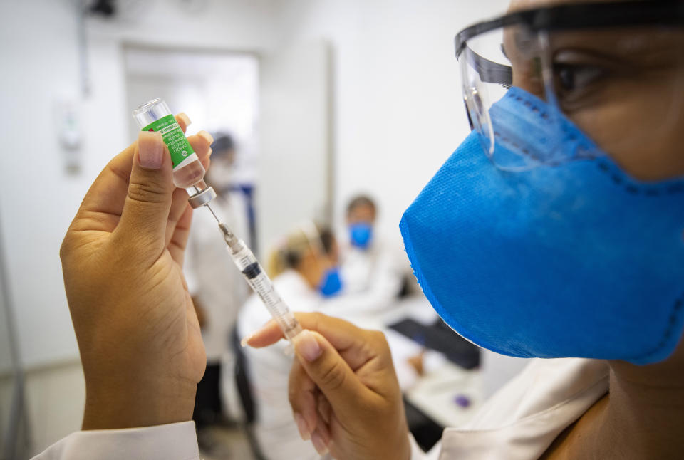 Una asistente de enfermería prepara una dosis de la vacuna Oxford-AstraZeneca para el COVID-19 durante un programa de vacunación prioritario para trabajadores de salud en un centro médico comunitario en Sao Paulo, Brasil, el miércoles 3 de febrero de 2021. (AP Foto/Andre Penner)