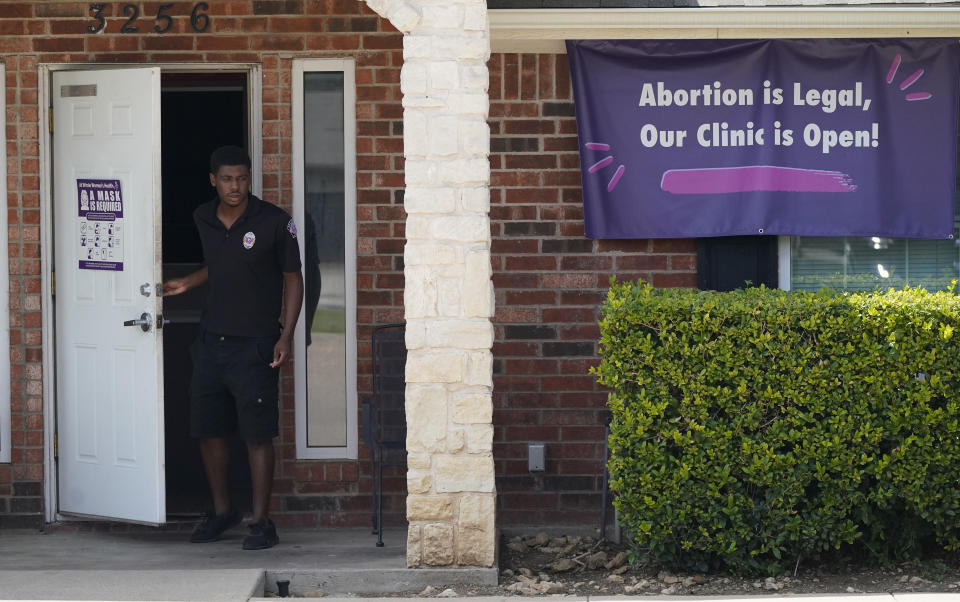 FILE - In this Wednesday, Sept. 1, 2021 file photo, a security guard opens the door to the Whole Women's Health Clinic in Fort Worth, Texas. A Texas law banning most abortions in the state took effect at midnight. (AP Photo/LM Otero, File)