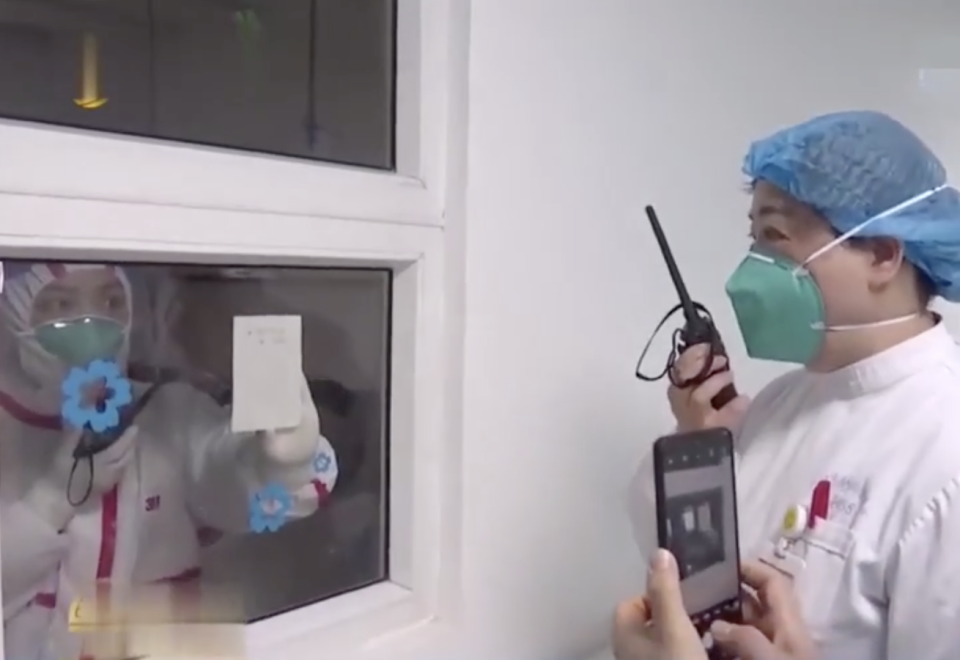 A doctor shows a message through a window inside a Wuhan hospital. Source: YouKu