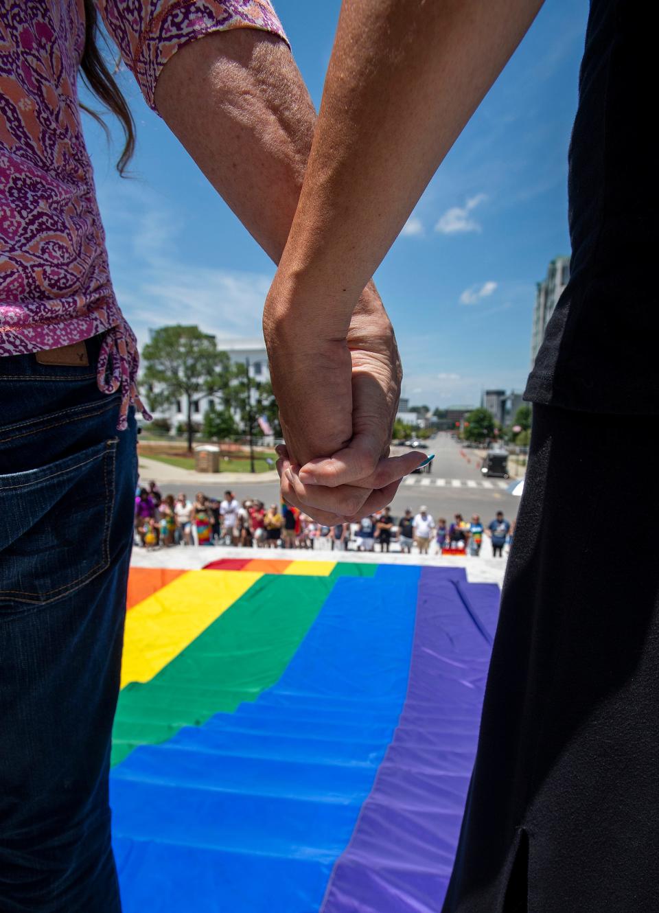 Marchers gather around a giant rainbow flag on the steps of the state capitol building during the Montgomery Pride March and Rally in downtown Montgomery, Ala., on Saturday June 29 , 2019. 