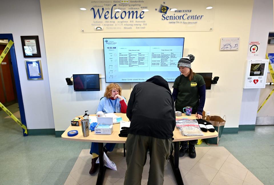 WORCESTER - Lois Luniewicz, left, and Heather Forchilli check in fellow volunteers and residents looking to get in out of the cold at the Worcester Senior Center Warming Center on Friday.