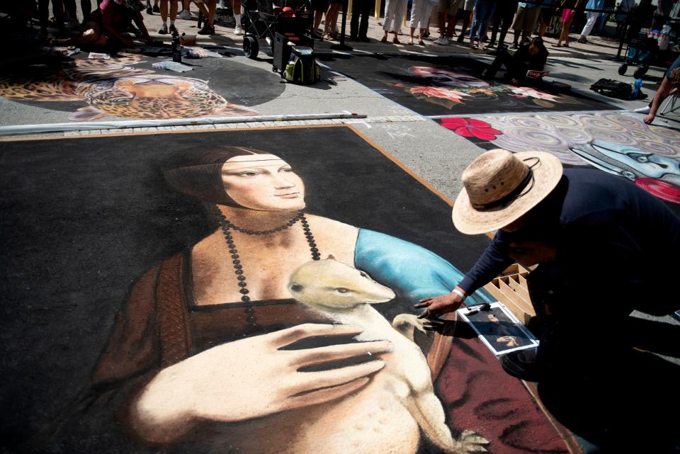 Artist Arturo Alazar paints a version of Leonardo da Vinci's "Lady With an Ermine" on Sunday at the Street Painting Festival.