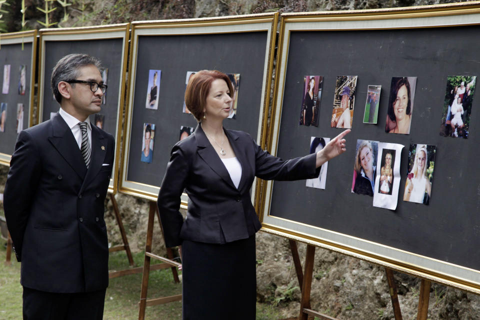 Australian Prime Minister Julia Gillard, right, accompanied by Indonesian Foregin Minister Marty Natalegawa, looks at photographs of victims of 2002 Bali Bombings at the Bali Memorial Service marking the 10th anniversary of the terrorist attacks at nightclubs in Kuta that killed 202 people, including 88 Australians and seven Americans, in Jimbaran hill, Bali, Indonesia on Friday, Oct. 12, 2012. (AP Photo/Johannes Christo, Pool)