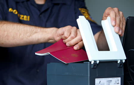 FILE PHOTO: Bavarian Police Officer controls passports at a temporarily checkpoint on the motorway between the Austrian and German border in Kirchdorf am Inn, Germany July 18, 2018. REUTERS/Michaela Rehle/File Photo