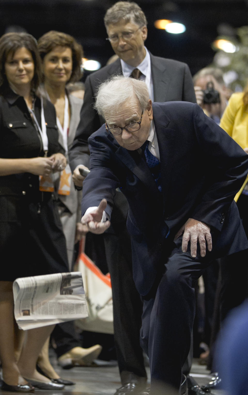 Warren Buffett, chairman and CEO of Berkshire Hathaway tosses a newspaper during a newspaper tossing competition in Omaha, Neb., Saturday, May 5, 2012. Bill Gates watches at rear. Berkshire Hathaway is holding it's annual shareholders meeting this weekend. (AP Photo/Nati Harnik)