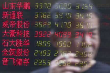 An investor is reflected on an electronic board showing stock information at a brokerage house in Shanghai, China, July 3, 2015. REUTERS/Aly Song