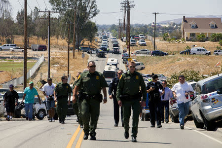 Buses packed with undocumented migrants retreat up the road after being stopped in their tracks by demonstrators in Murrieta, California July 1, 2014. REUTERS/Sam Hodgson