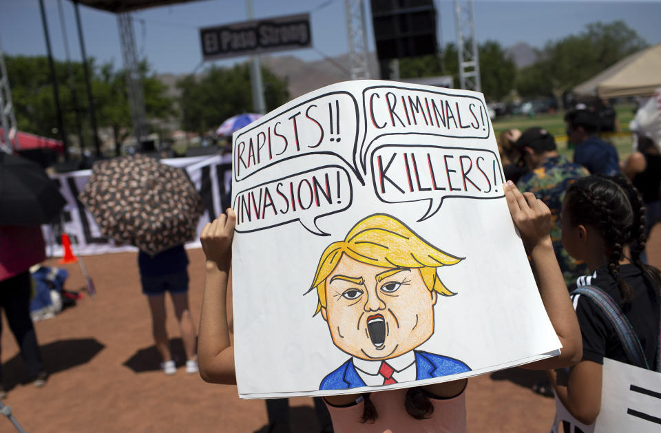 A demonstrator holds a sign to protest the visit of President Donald Trump to the border city after the Aug. 3 mass shooting in El Paso, Texas, Wednesday, Aug. 7, 2019. Trump headed to El Paso, after visiting Dayton, Ohio on Wednesday to offer a message of healing and unity, but he will be met by unusual hostility in both places by people who fault his own incendiary words as a contributing cause to the mass shootings. (AP Photo/Andres Leighton)