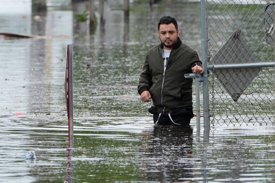 Man stands near the flooded parking lot of his apartment building, Thursday, June 13, 2024, in Hallandale, Florida (AP)