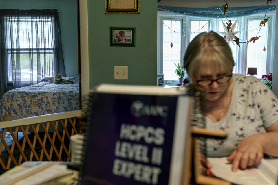 Ellen Booth estudia para ser codificadora médica en su casa de Coventry, Rhode Island, el 17 de mayo del 2021. No quiere volver a su viejo trabajo en un restaurante cuando pase la pandemia del coronavirus. (AP Photo/David Goldman)